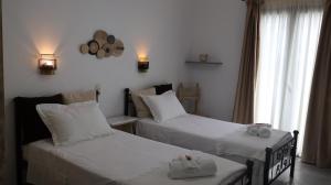 a bedroom with two beds and a window at Pension Sofia in Parikia