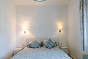 una camera da letto con un letto con due cuscini blu di La Platea Rural a Siviglia Altre 41 foto