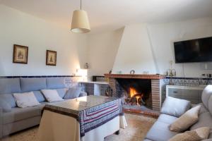 un soggiorno con divano e camino di La Platea Rural a Siviglia