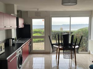 cocina con mesa y sillas y vistas al océano en T2 37 M2 les pieds dans l'eau, en Ploemeur