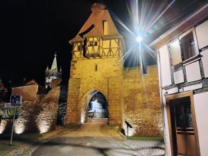 un edificio con una torre de reloj por la noche en Gîte avec parking, au calme, entre Colmar-Riquewihr et Obernai ,marchés de Noël, 3 chambres, avec terrasse, en Châtenois