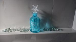 a blue bottle sitting on a shelf with beads at Pension Sofia in Parikia