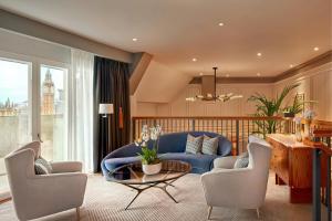 a living room with a blue couch and chairs at London Marriott Hotel County Hall in London