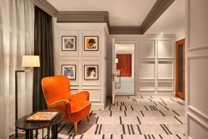a hallway with an orange chair and a table at London Marriott Hotel County Hall in London