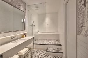 a white bathroom with a tub and a sink at London Marriott Hotel County Hall in London