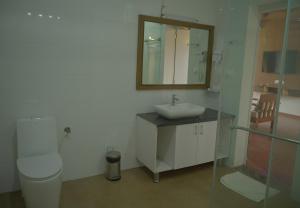a bathroom with a toilet and a sink and a mirror at Gavadana Resort Coorg in Madikeri +52 photos