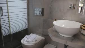 a white bathroom with a sink and a toilet at Pension Sofia in Parikia