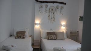 a bedroom with two beds and a clock on the wall at Pension Sofia in Parikia