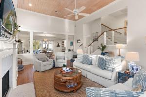 a living room with white furniture and a fireplace at Delahunt Cottage - 4218 Seventh Street in Saint Simons Island