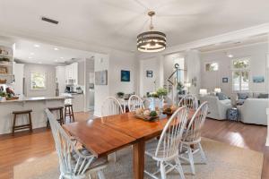 a kitchen and living room with a wooden table and chairs at Delahunt Cottage - 4218 Seventh Street in Saint Simons Island