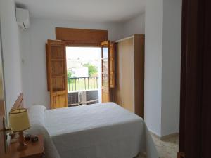a bedroom with a bed and an open door at Casa Montilla in Granada
