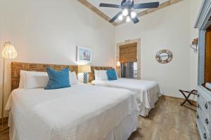 two beds in a white room with blue pillows at Spanish Key 705 in Perdido Key +35 photos