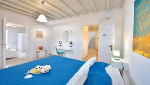 Un dormitorio con una cama azul con un plato. en Villa E, en Mykonos ciudad 18 fotos más
