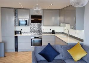 a kitchen with a blue couch in a room at Penthouse apartment with stunning sea views in Penmaen-mawr