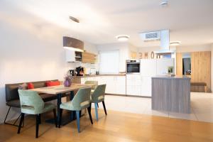 a kitchen and dining room with a table and chairs at Appartement Deluxe mit Garten stilvoll wohnen und entspannen 12 Min vom Europa Park in Schwanau