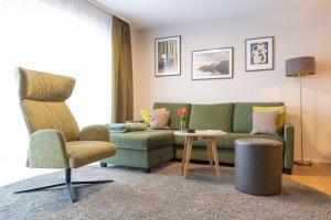 シュヴァナウにあるAppartement Deluxe Winterzauber nahe Europa Parkの緑のソファと椅子のあるリビングルーム +36枚の写真