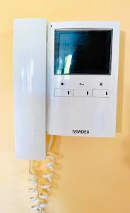 a white phone with a handset attached to a wall at Cosy 3 Bed House at CityCentre & Garden & FreeParking in Newcastle upon Tyne