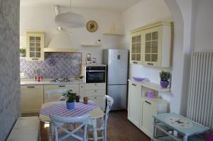 a kitchen with a table and a white refrigerator at Lullaby Holiday in Trieste
