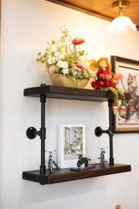 a shelf with flowers and a mirror on a wall at Le-Mao Chiang Dao in Chiang Dao +269 photos