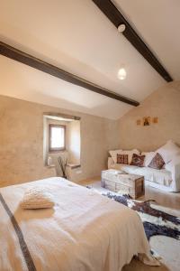 Un dormitorio con una cama grande y un sofá. en L'appart du Mas de la Costete Mons-Olargues-Caroux, en Mons