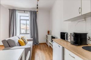 a living room with a couch and a kitchen at Apartamentos Casas da Travessa T0 T2 T3 in Horta