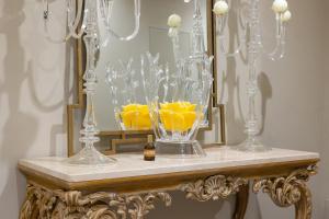 a table with two glass vases and a mirror at Five by Capri 5 Senses in Anacapri