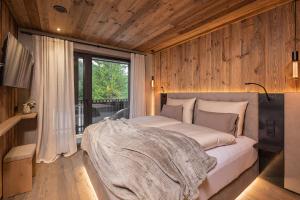 una camera da letto con un letto in una stanza con pareti in legno di Luxury Chalet Tre Cime mit Privat Spa & Pool a Sesto Altre 46 foto