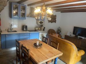 a kitchen with a wooden table and a dining room at Casa Pinhão in Sabugueiro
