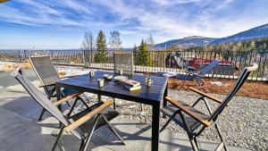 卡尔帕奇Apartament Orlik 006 z ogrodem i widokiem na Śnieżkę - 5D Apartments的露台上的桌子和椅子，背景是群山