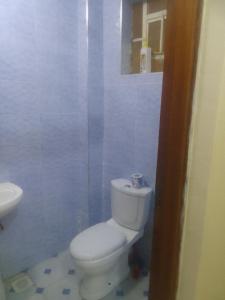 Un baño con un inodoro blanco y un lavabo. en Kinoo Stays, en Rungiri