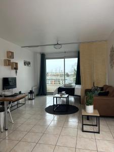 a living room with a couch and a table at Studio lumineux sans vis a vis avec balcon privé in Chelles