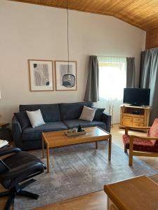 a living room with a blue couch and a coffee table at Ferienwohnung Markt Eging am See Bayerischer Wald in Eging am See