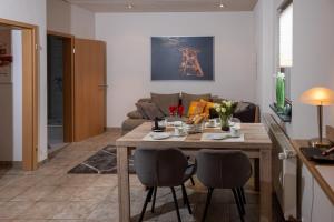 a kitchen and living room with a wooden table and chairs at FeWo Severin in Bottrop