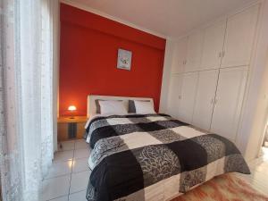 a bedroom with a bed and a red wall at River House in Kalabaka