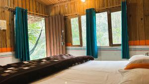 ein Schlafzimmer mit einem großen Bett und blauen Vorhängen in der Unterkunft Rishikesh Valley in Rishikesh + 49 Fotos