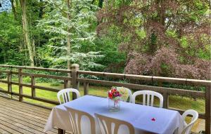 a table with chairs and a vase of flowers on a deck at Amazing Home In Sainte-Marguerite-Sur- in Sainte-Marguerite +14 photos