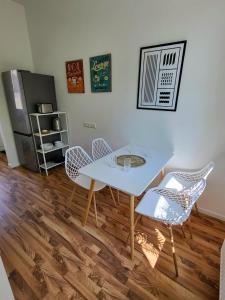 a dining room with a white table and chairs at Suite 3 - Apartments am Schloss in Oberschleißheim +3 photos
