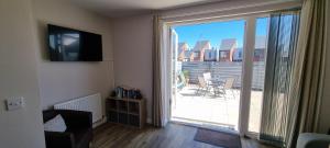 un soggiorno con porta scorrevole in vetro che si apre su un patio. di Sunrise Cottage, 2 minutes walk from the beach! a Woodhorn
