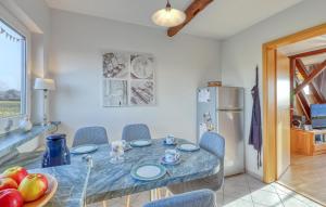 a dining room with a table and chairs and a refrigerator at Gorgeous Apartment In Nübel Ot Brekling in Brekling