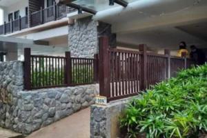 ein Gebäude mit einem Holzzaun und einigen Pflanzen in der Unterkunft Carl's Brenthill Accommodation in Baguio City