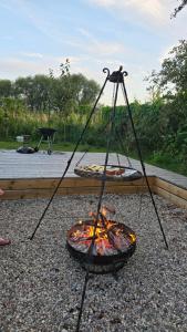 a fire pit with a grill in a yard at Piaski Rogowa in Rogowo
