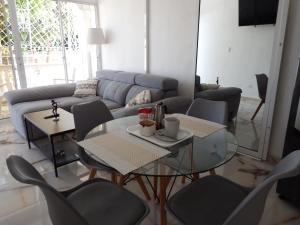 a living room with a couch and a table and chairs at APE Dream Villa in Itabo