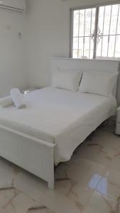 a white bed in a room with a window at APE Dream Villa in Itabo