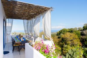 a balcony with a table and chairs and flowers at Villa Lira The Hidden Gem Above the Sea in Rethymno Town