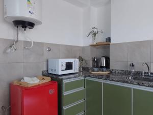 cocina con nevera roja y microondas en Belgrano 210, en Canals