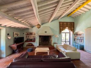 Una sala de estar con un sofá y una chimenea. en Madeleine: Luxury Villa in Italy, en Case Galli