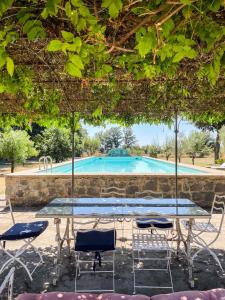 Una mesa y sillas frente a una piscina. en Madeleine: Luxury Villa in Italy, en Case Galli