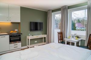 a bedroom with a white bed and a sink at Ferienapartment Alte Bücherei in Mittelangeln