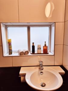 a bathroom mirror with a sink and a window at Ons kleine huisje in Gasselte +33 photos