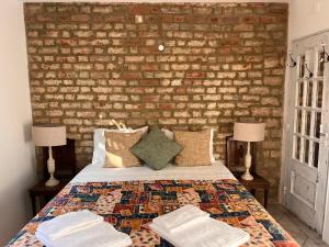 a bedroom with a brick wall and a bed with two lamps at Snug Houseguests in Lisbon